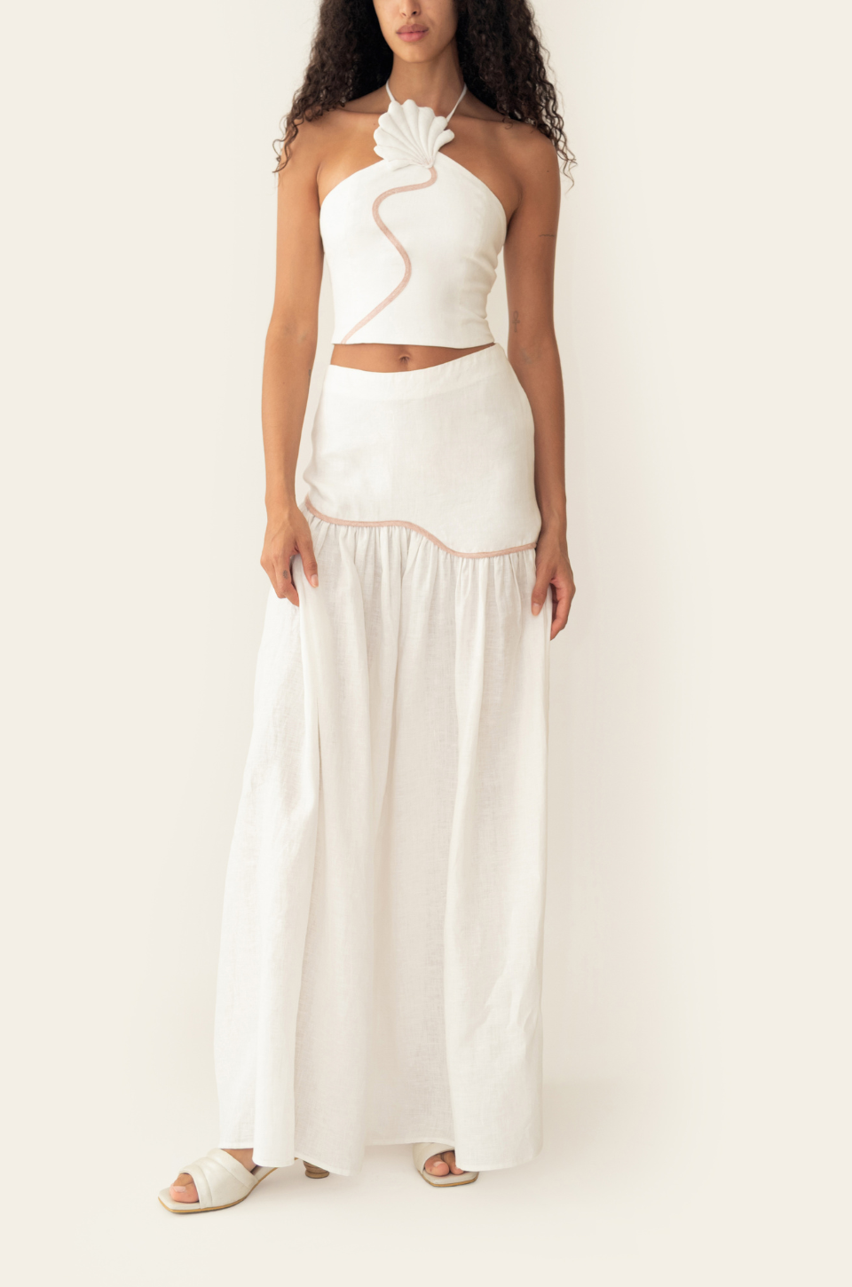 Azulu Leia Skirt and Leia Top in white linen, front view of the halter crop top and gathered floor-length skirt with blush contrast piping