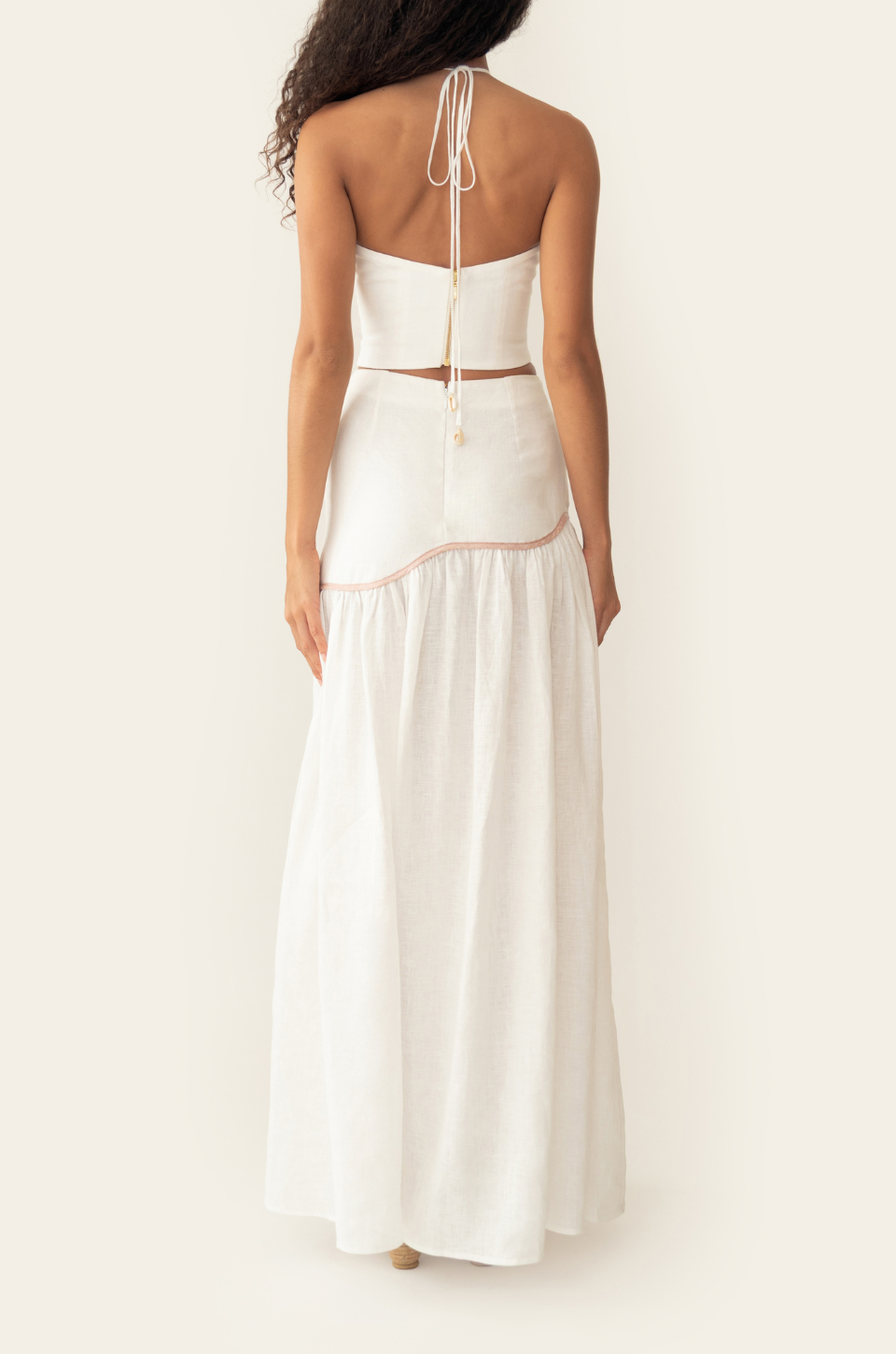 Azulu Leia Skirt and Leia Top in white linen, back view with halter tie and pink piping along the dropped yoke of the maxi skirt